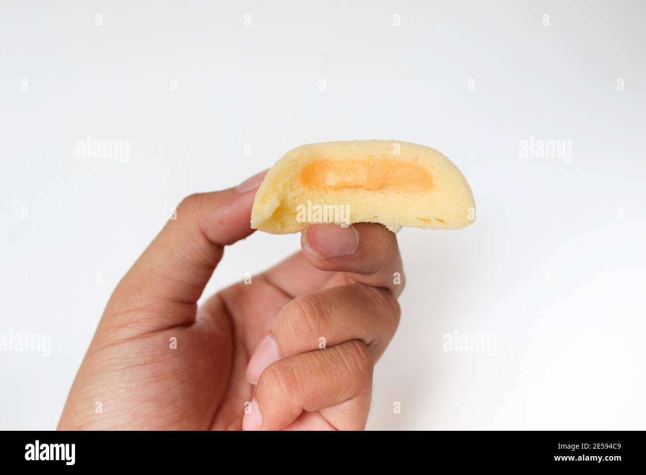 Bakpia Kukus Kuchen oder gedämpfte Bakpia Kuchen mit Käse Geschmack auf der Hand isoliert auf weißem Hintergrund. Indonesien-china traditionelle Torte aus yogyakarta Stockfoto