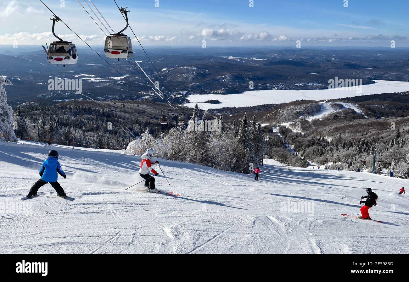 Skifahrer auf Mont Tremblant Pisten mit Gondeln im Hintergrund, Quebec, Kanada Stockfoto