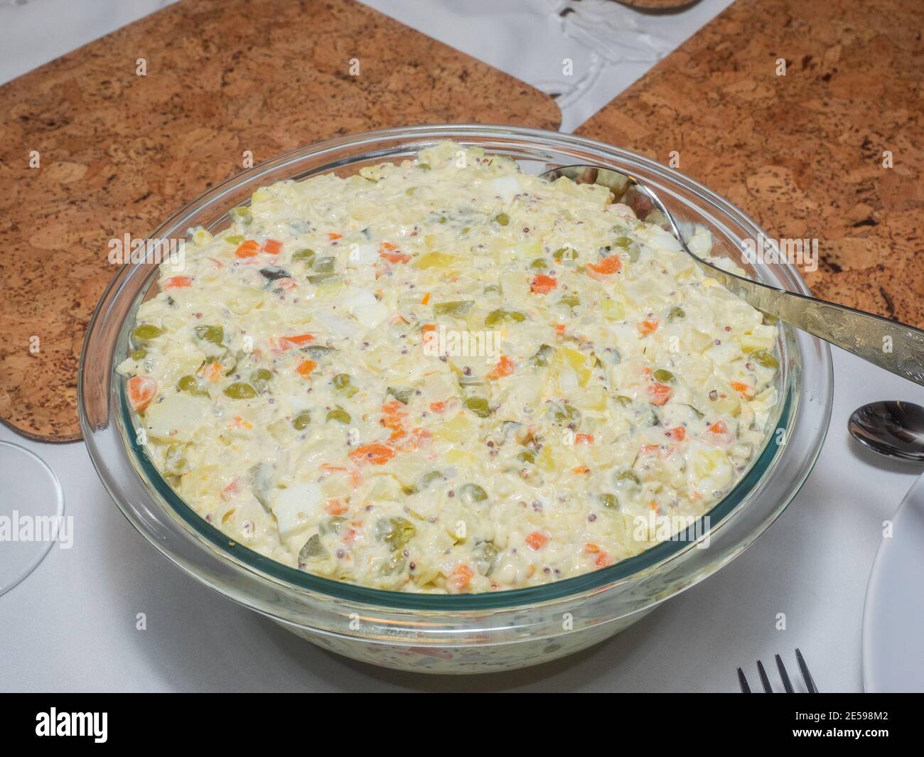Salade Olivier ist ein Salat aus gewürfelten Kartoffeln, Gemüse und manchmal Fleisch in Mayonnaise gebunden. Stockfoto