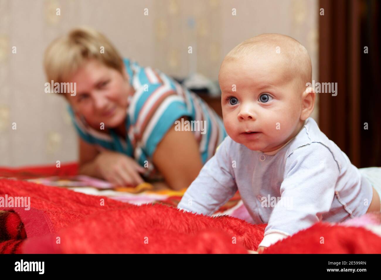 Denkendes Baby mit seiner Großmutter auf einem Bett Stockfoto