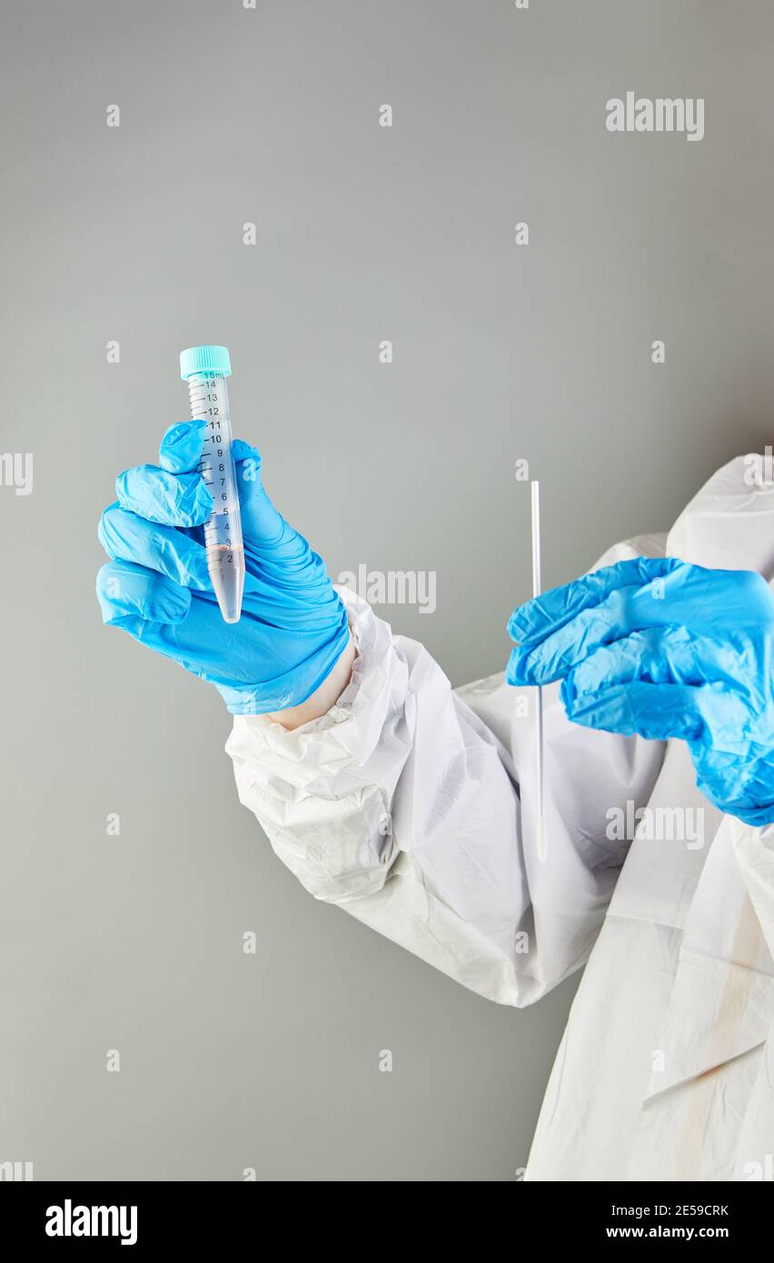 Coronavirus Test - EIN Arzt mit einem Reagenzglas Und Tupfer für eine Coronavirus-Probe, die isoliert ist Kittel oder Schutzanzüge und Stockfoto