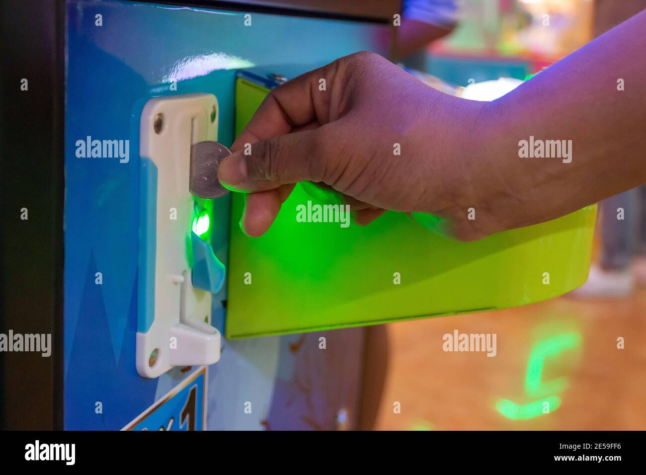 Legen Sie eine Münze in die Spielkonsole für Kinder ein einkaufszentrum Stockfoto