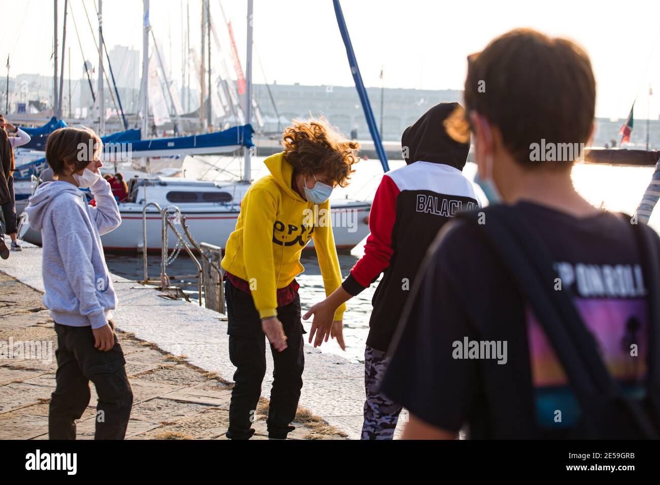 Triest, Italien - Oktober 10: Junge Jungs spielen klatschende Hände am Meer am 10. Oktober 2020 Stockfoto