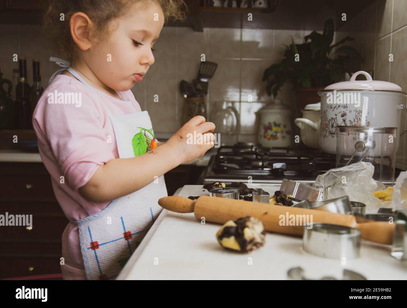 Mädchen in einer Küche. Glückliche Familie lustige Kinder Vorbereitung Teig, gebackene Cookies in der Küche, selektive Fokus Hände. Stockfoto