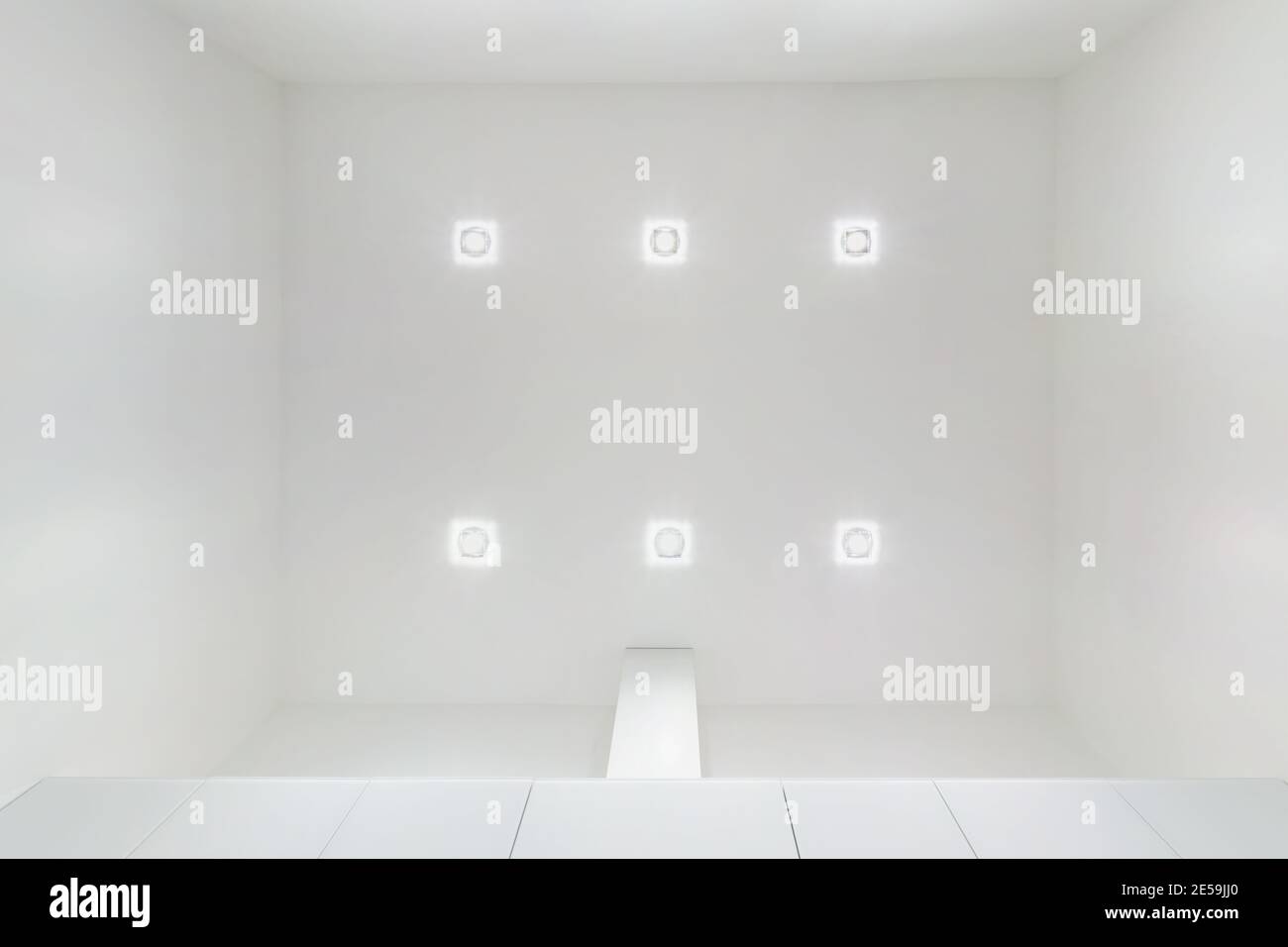 Abgehängte Decke mit Halogenstrahlern und Trockenmauerkonstruktion im leeren Raum in Wohnung oder Haus. Stretchdecke weiß und komplex. Stockfoto