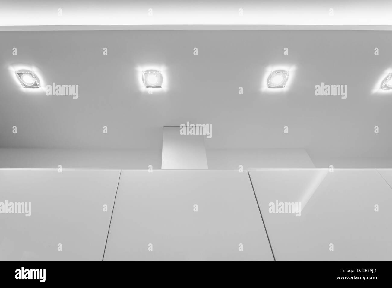 Abgehängte Decke mit Halogenstrahlern und Trockenmauerkonstruktion im leeren Raum in Wohnung oder Haus. Stretchdecke weiß und komplex. Stockfoto
