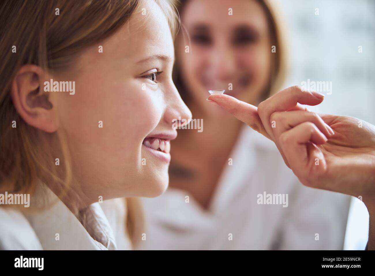 Junge Teenager Mädchen Auswahl und versuchen Linsen in Augenheilkunde Klinik Stockfoto