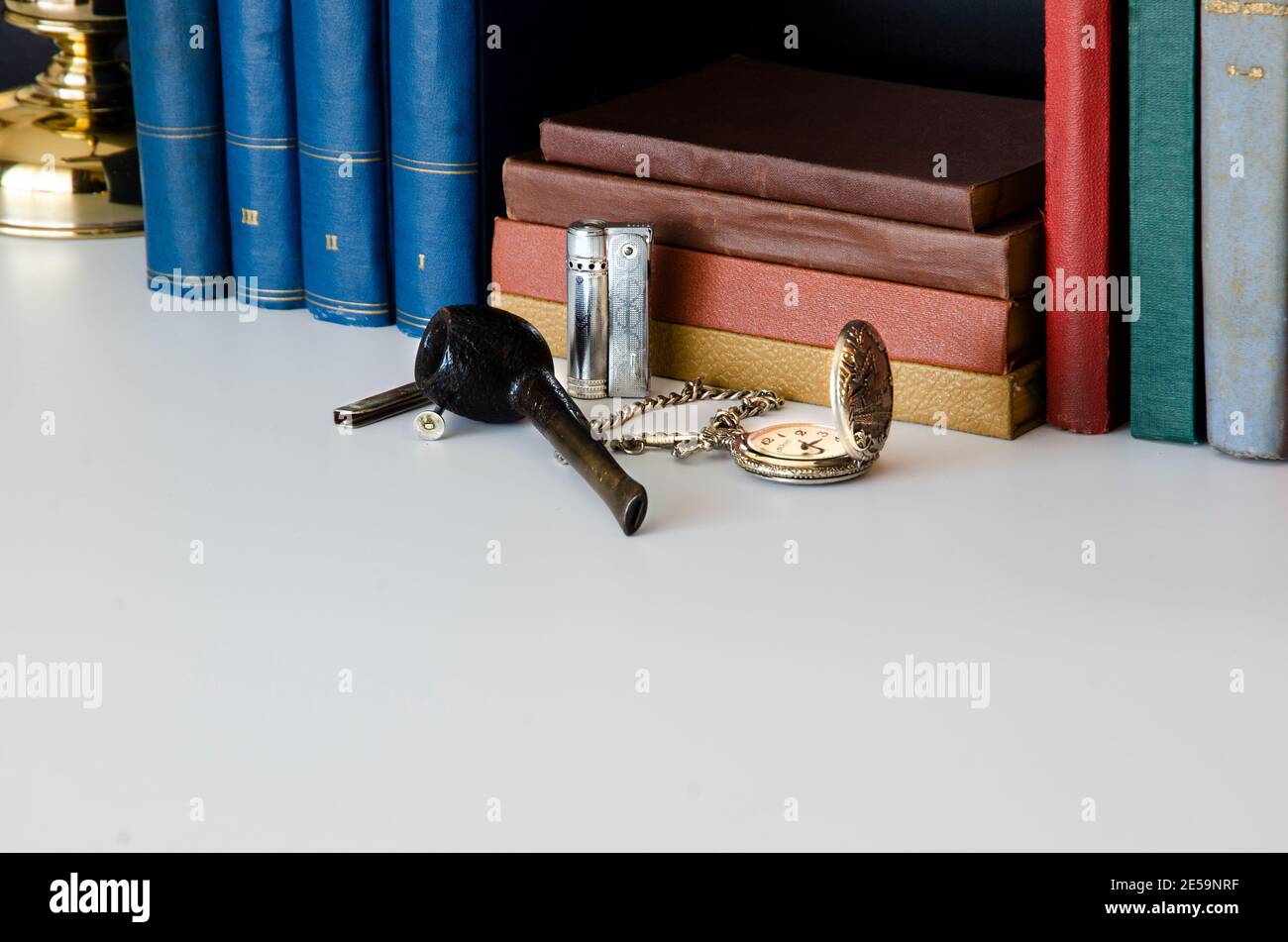 Bücher, Literatur, Wissensbibliothek, Feuerzeug, Feuerstein, Rauchpfeife und alte Uhr. Sherlock Holmes Büroschalter Stockfoto