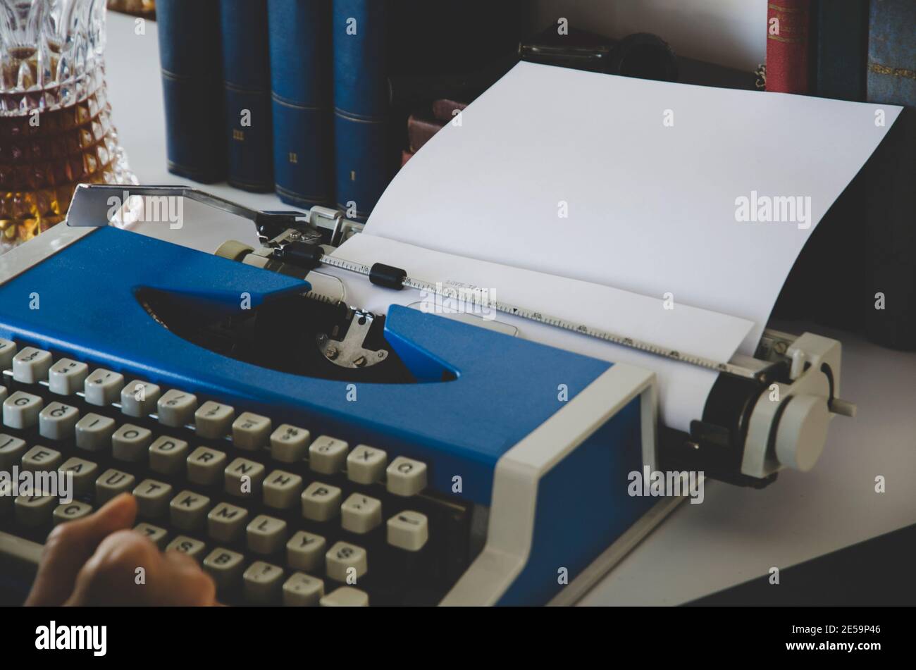 Vintage-Foto von alten Büchern. Die Hand des Schriftstellers ist auf der Schreibmaschine .Writer Schreiben eines Liebesromans. Romancier schreibt Roman auf einer Schreibmaschine Stockfoto