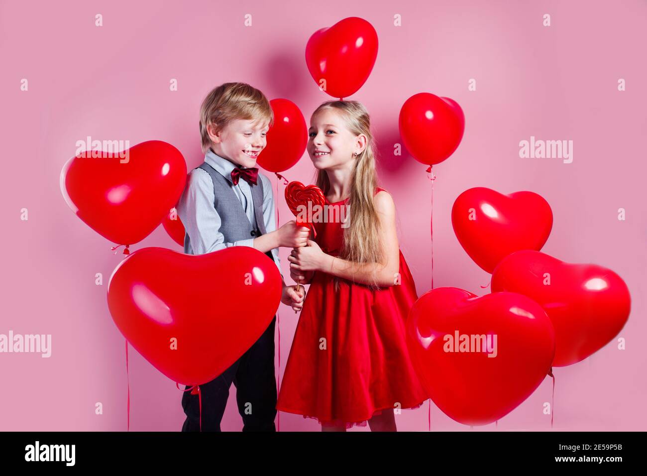 Lustige Junge Und Kleines Madchen Mit Sussigkeiten Roten Lollipop In Herzform Schone Kinder Essen Sussigkeiten Auf Rotem Herz Hintergrund Valentinstag Konzept Stockfotografie Alamy