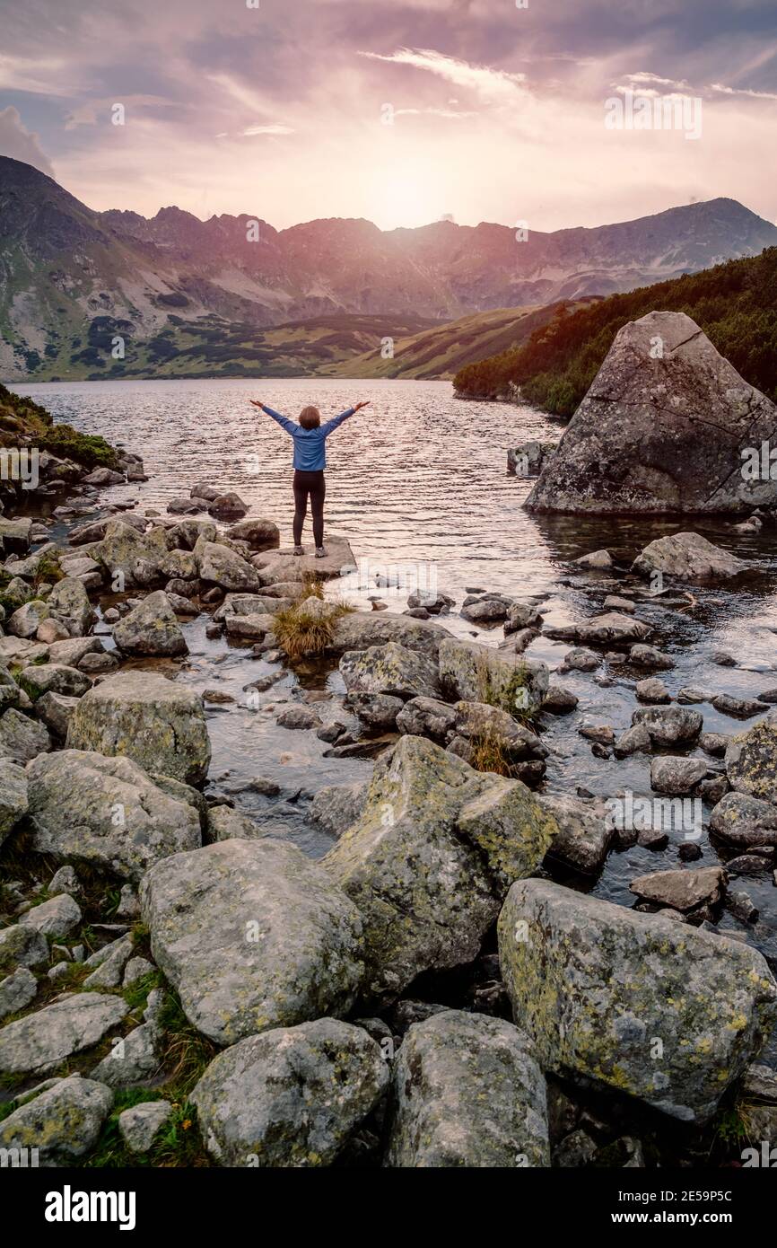 Wanderer Frau erkunden die fantastische Landschaft und genießen Sie die Aussicht in der Nähe eines Bergsees mit erhobener Hand, hohe Tatra, Polen Stockfoto