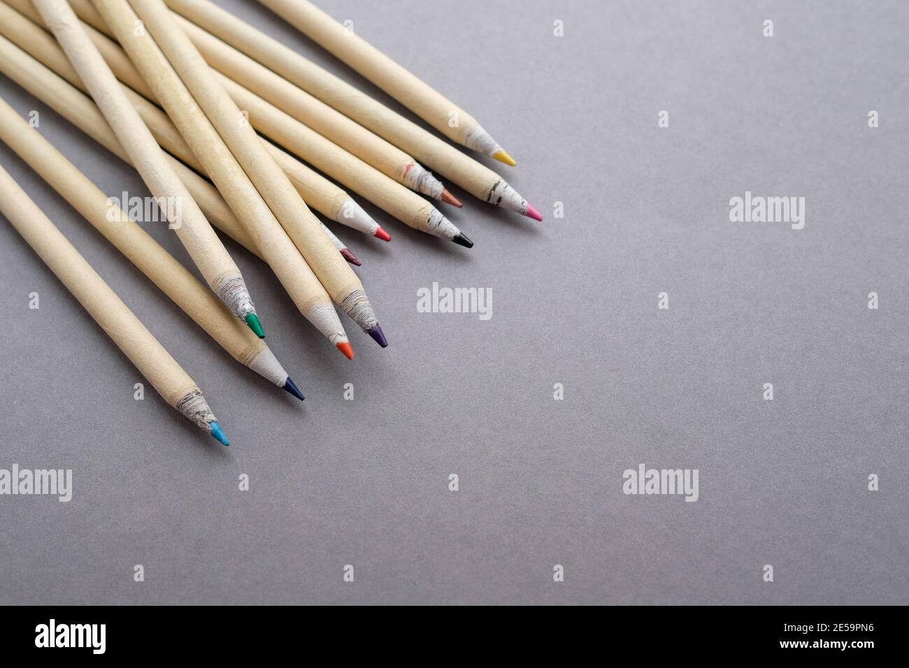 Bleistifte aus umweltfreundlichen Materialien liegen auf grauem Hintergrund. Es gibt einen Platz für Text. Stockfoto