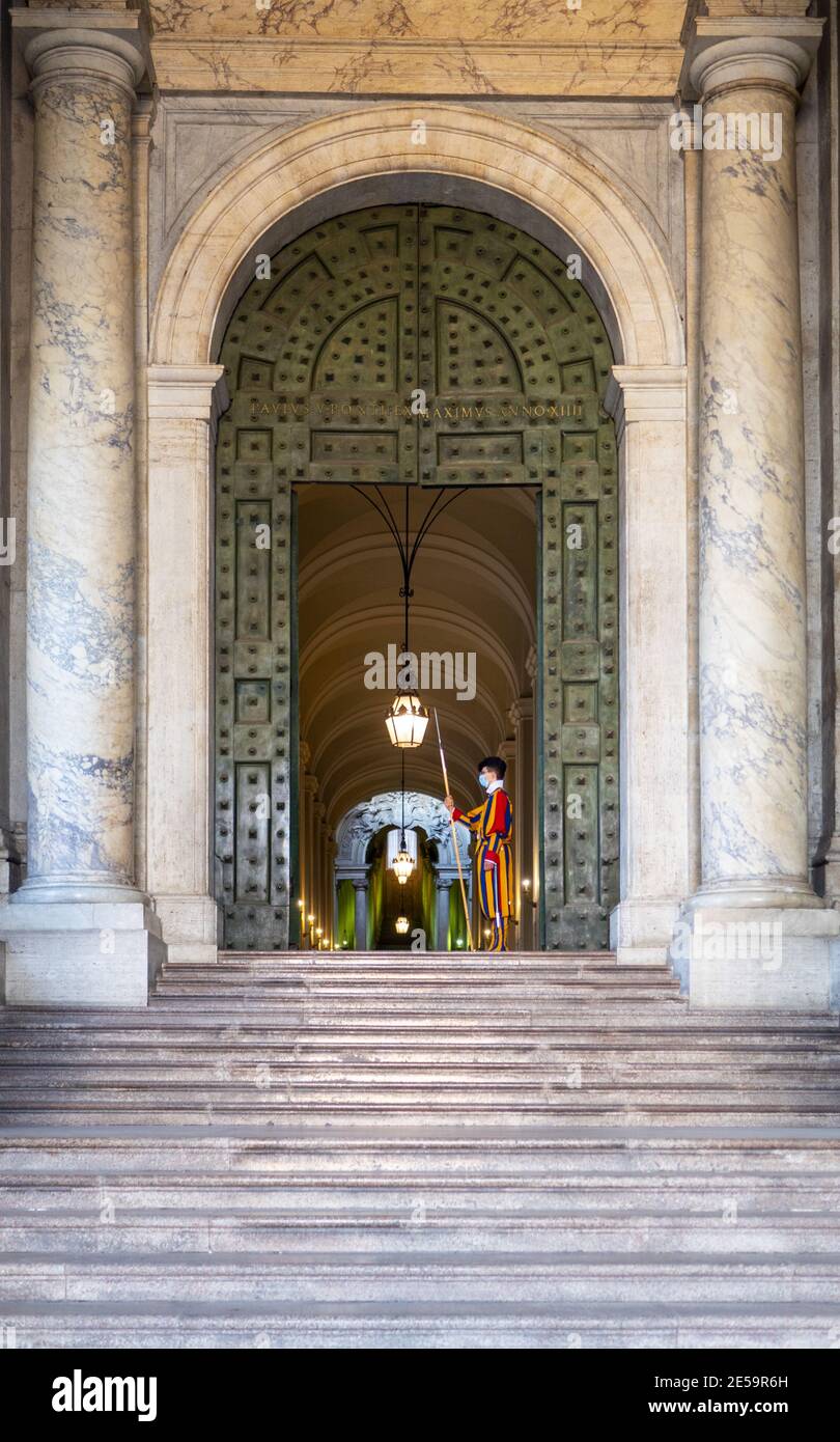 ROM, ITALIEN - 26. Jan 2021: Der Vatikanische Eingang links von der Peterskirche in Rom. Die Schweizer Garde trägt eine medizinische Maske aufgrund des Covid-19 Corona Virus Stockfoto