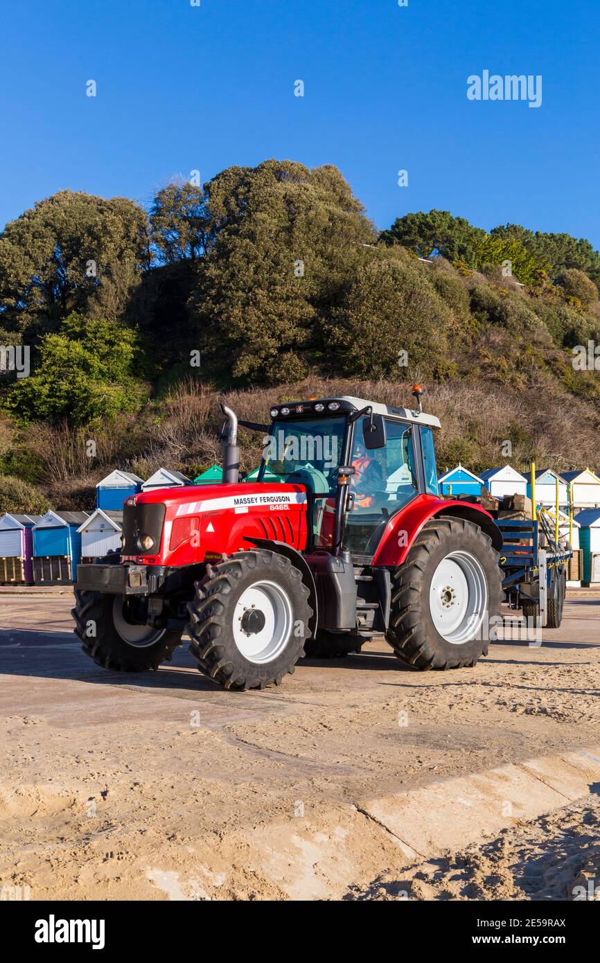 Programm zur Erneuerung der Holzgroyne, das im Januar in Alum Chine, Bournemouth, Dorset UK stattfindet - Massey Ferguson Dyna-6 6465 Traktor, der alte Groynes bewegt Stockfoto