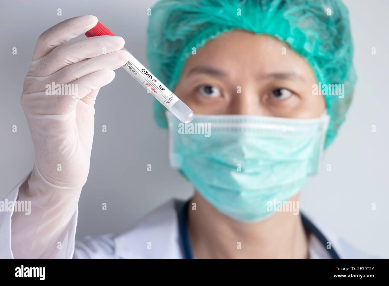 Coronavirus COVID-19 Testkonzept. Arzthand mit Handschuh hält Reagenzglas mit Patienten Nasensekretionsprobe für positive Corona-Virus-Infektion Stockfoto