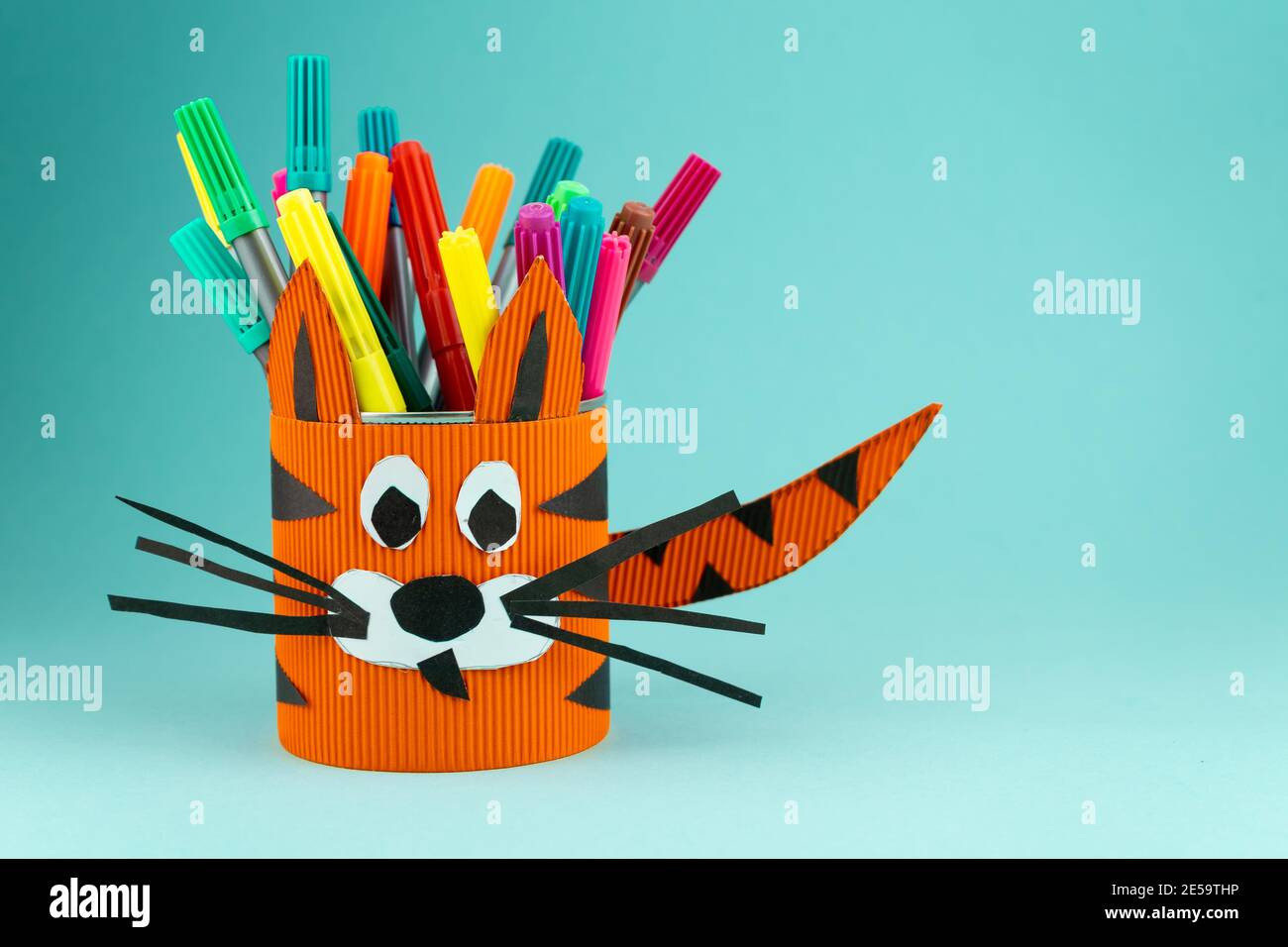 Schritt 9. Schritt-für-Schritt-Anleitung, wie man aus einer Blechdose einen Ständer für Schreibwaren macht. Tiger aus Papier und Pappe, Schere und Kleber. Ein Spaß DI Stockfoto