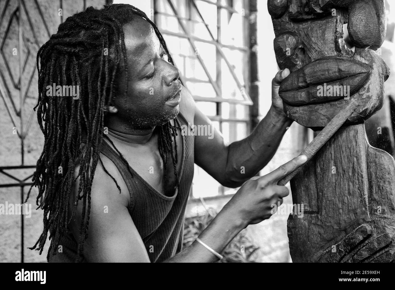 JOHANNESBURG, SÜDAFRIKA - 05. Jan 2021: Johannesburg, Südafrika - 17. Januar 2011: Afrikanischer Mann Bildhauer Schnitzerei eine traditionelle Statue aus woo Stockfoto