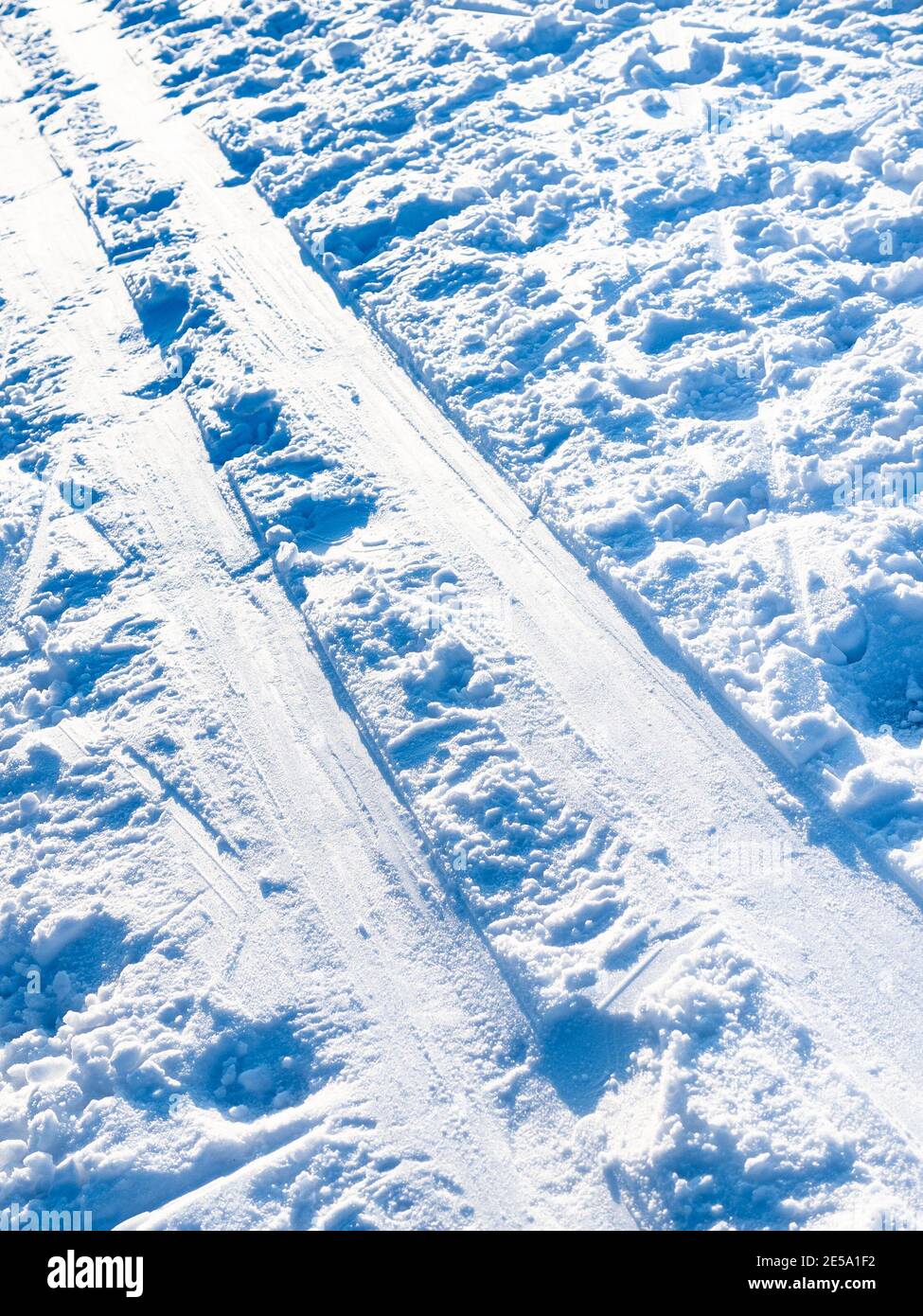 Die sonnenbeschienene Skipiste leuchtet auf schneebedeckter gefrorener Oberfläche aus nächster Nähe Des Flusses auf kalt in kalten sonnigen Wintertag Stockfoto