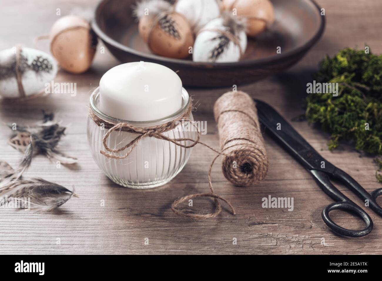 Frühling Dekor Ideen DIY. Wie man Ostern Blumenarrangement macht. Einen Kerzenständer mit Jute Garn verzieren. Schritt für Schritt, Tutorial. Stockfoto