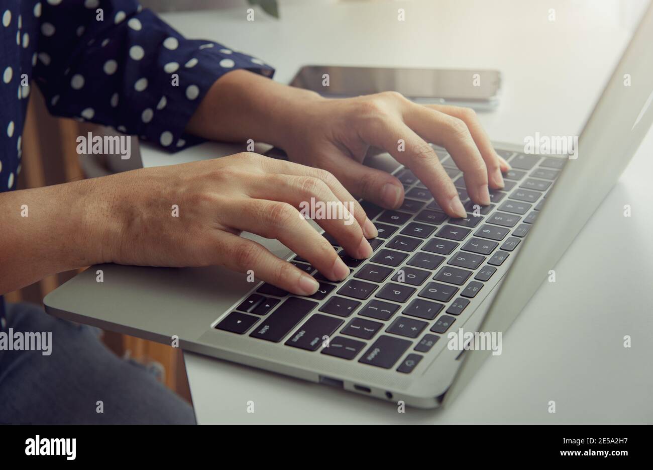 Die Hand der Frau mit einer Tastatur auf einem Laptop-Computer. Geschäftskonzept. Arbeiten Sie von zu Hause aus. Stockfoto