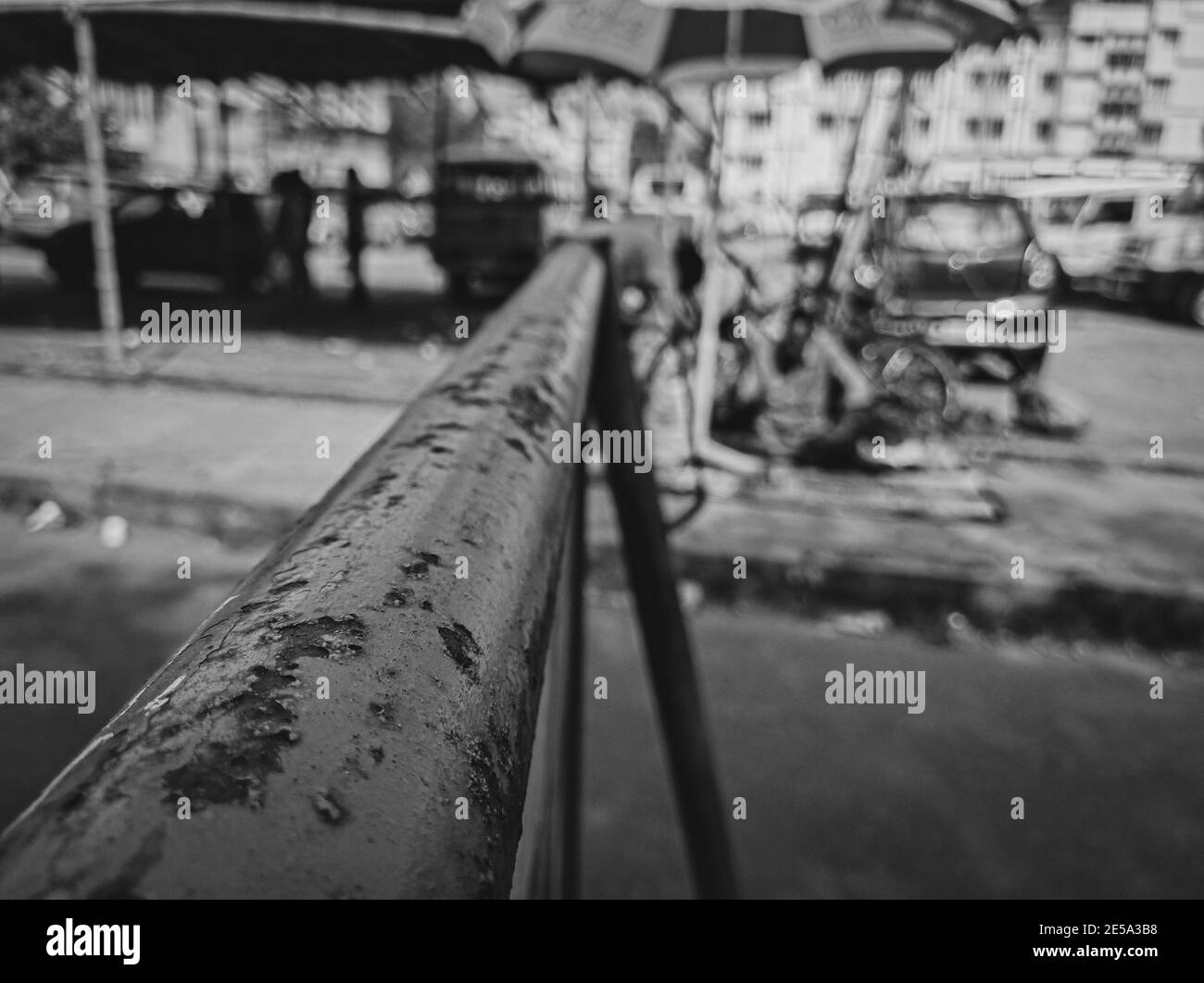 Graustufenaufnahme einer verrosteten Röhre auf der Straße Stockfoto