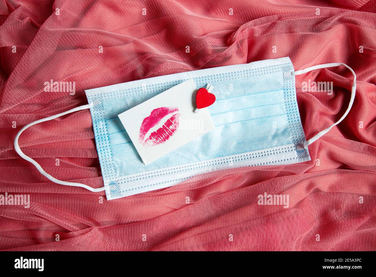 Aufkleber mit Kuss auf rosa Stoff, Valentinstag Hintergrund Stockfoto