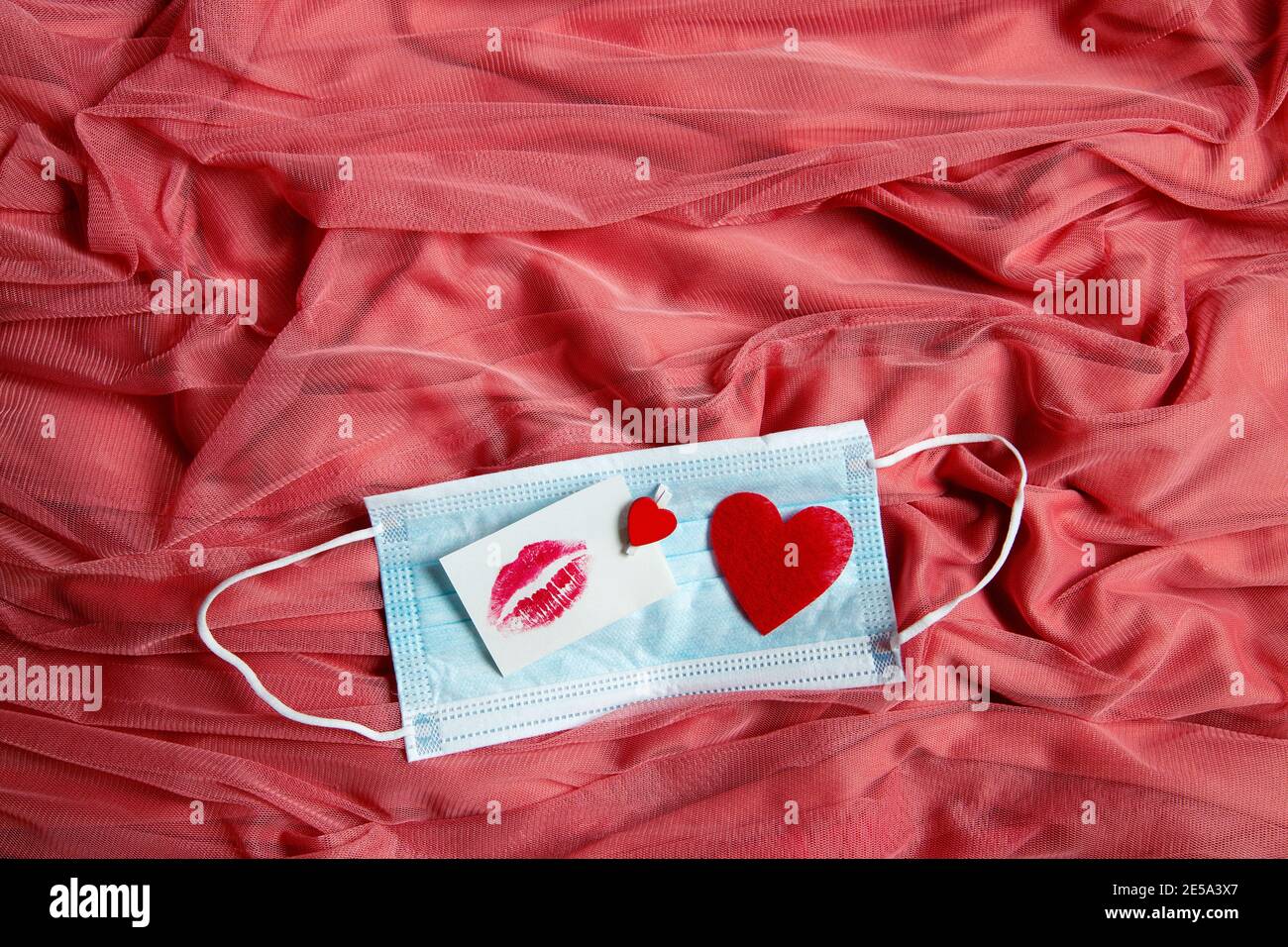 Aufkleber mit Kuss auf rosa Stoff, Valentinstag Hintergrund Stockfoto