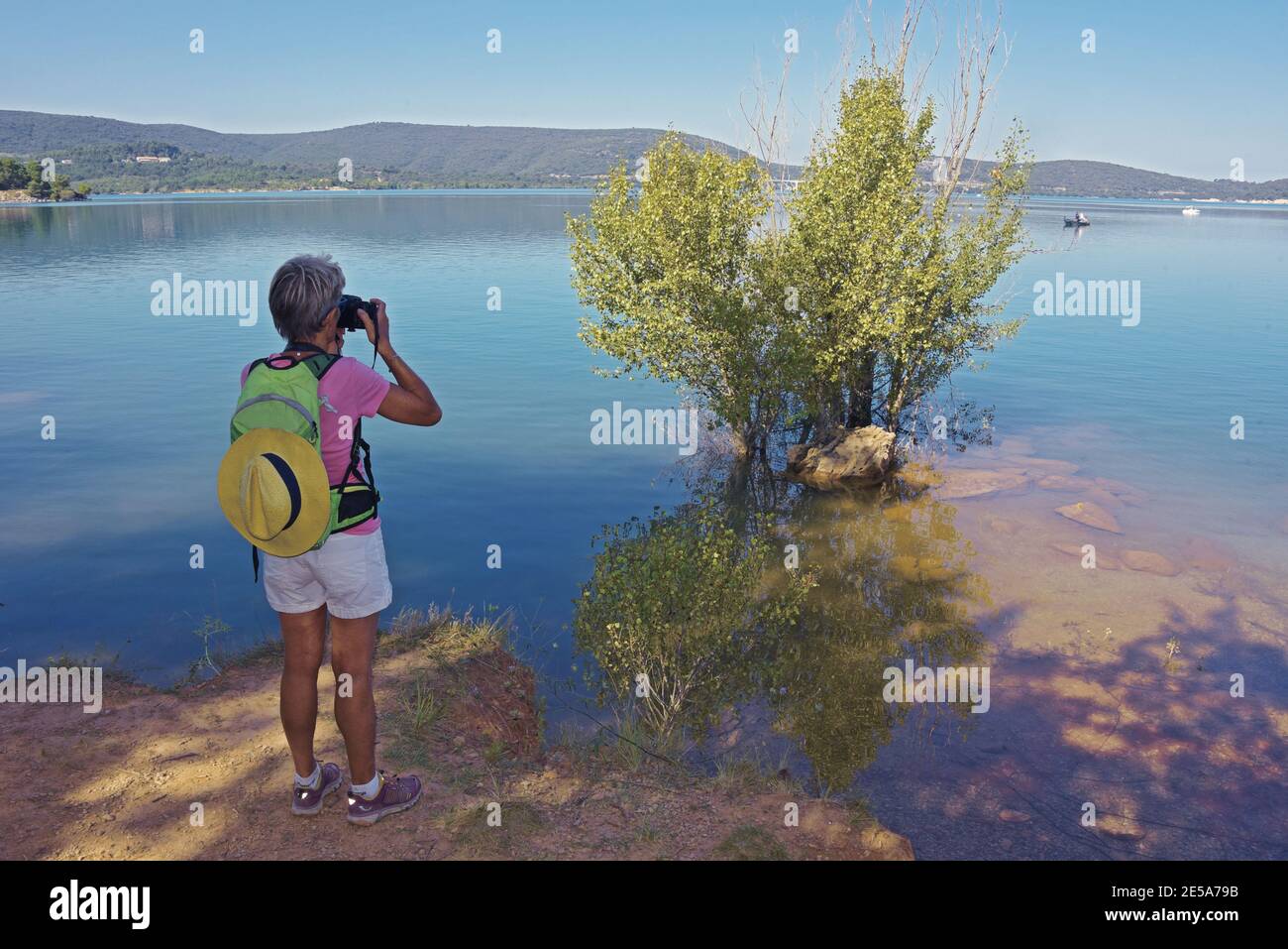 Frau, die am Seeufer steht und ein Foto macht, Lac de Sainte-Croix, Frankreich, Dept Var, Bauduen Stockfoto