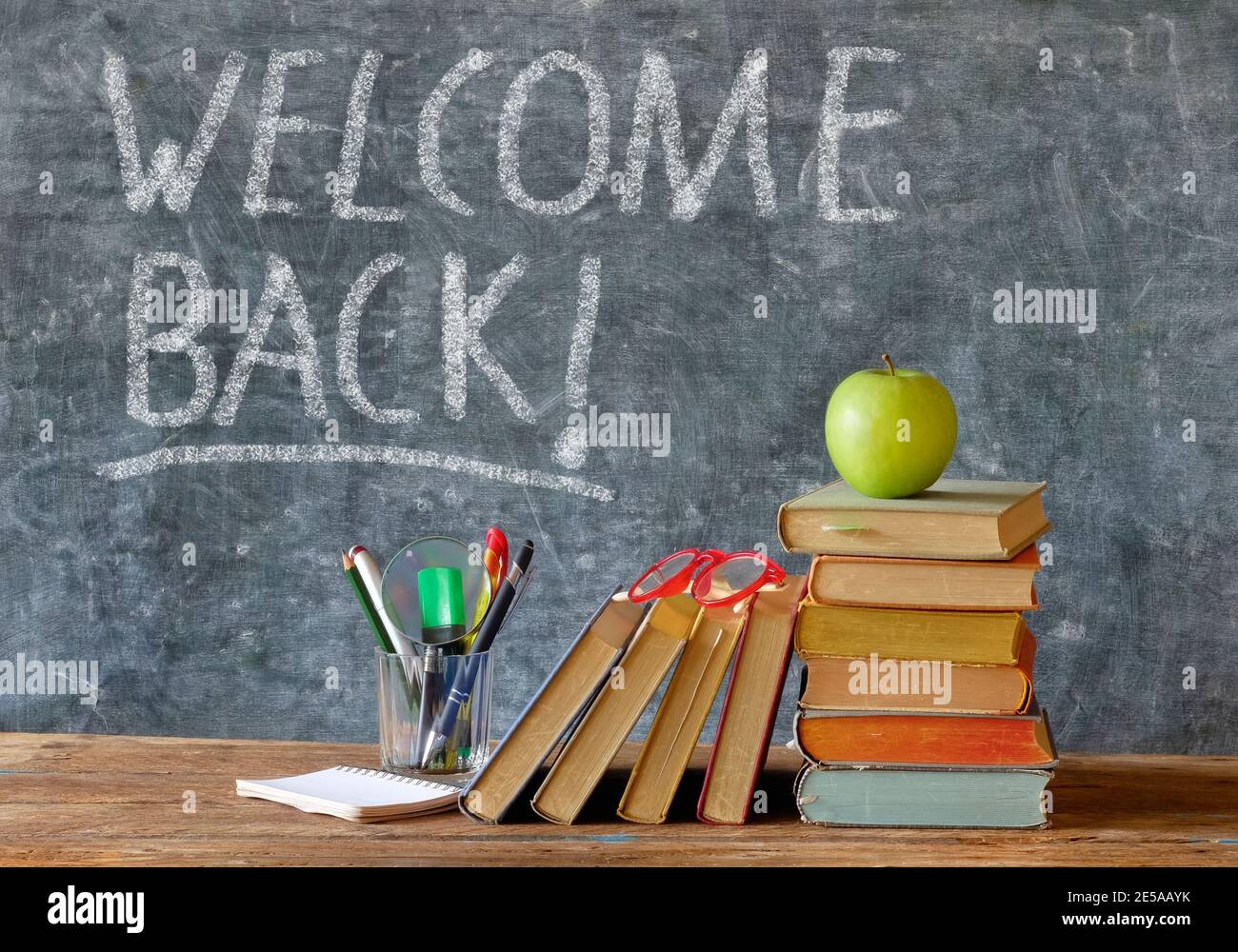 Wiedereröffnung von Schulen nach Corona Lockdown, Schulbedarf, Bücher, Tafel mit Willkommensnachricht, Konzept Stockfoto