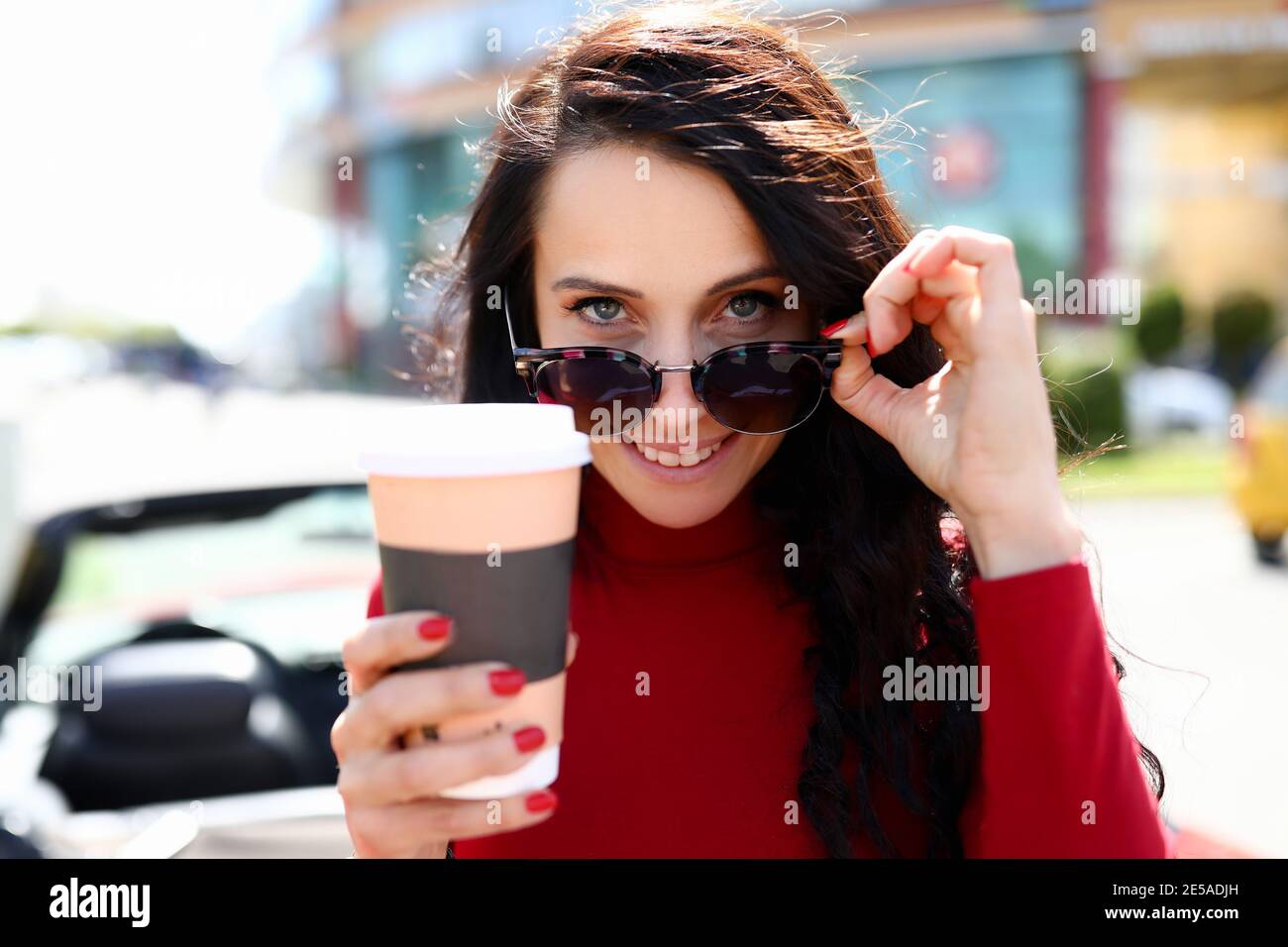 Portrait der Brünette Frau in Sonnenbrille mit einer Tasse Kaffee In Händen Stockfoto