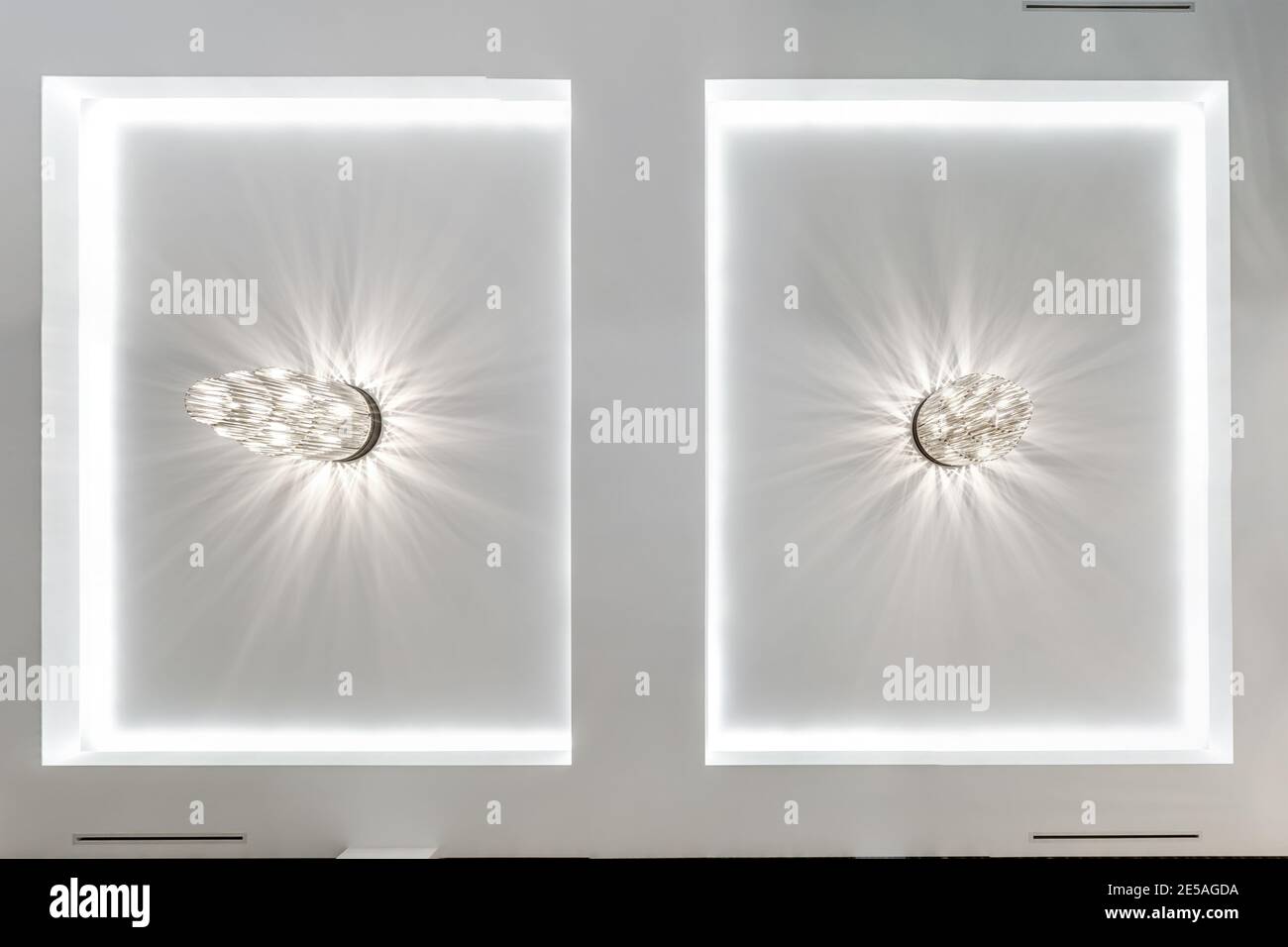 Blick auf die abgehängte Decke mit Halogenstrahlern und Trockenmauerkonstruktion im leeren Raum in Wohnung oder Haus. Stretchdecke weiß und kpl Stockfoto