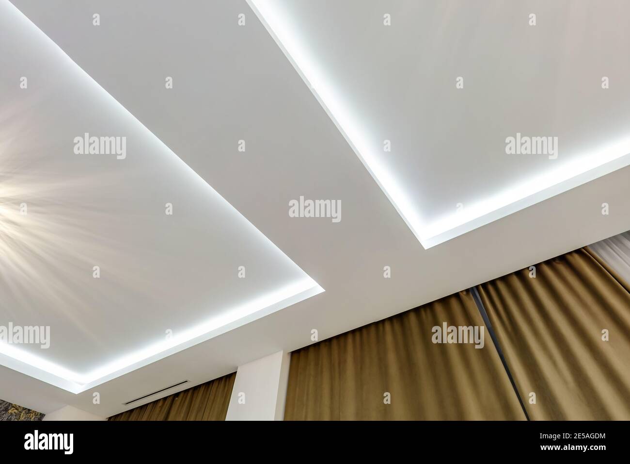 Blick auf die abgehängte Decke mit Halogenstrahlern und Trockenmauerkonstruktion im leeren Raum in Wohnung oder Haus. Stretchdecke weiß und kpl Stockfoto