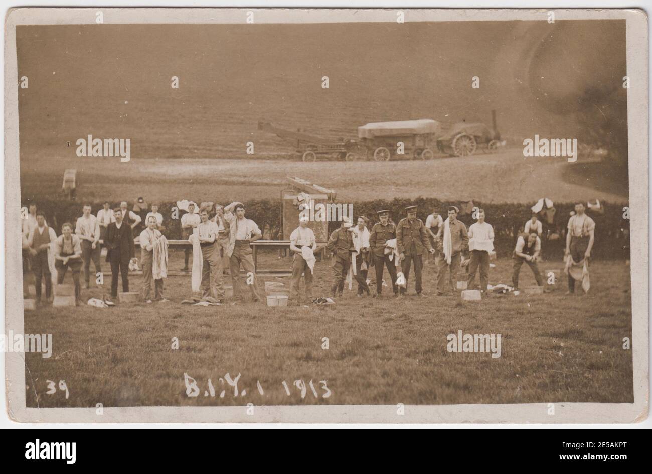 Soldaten im Bedfordshire Imperial Yeomanry (BIY) werden nach den Übungen im Jahr 1913 gewaschen. Der Waschtisch ist auf einem Feld aufgestellt und im Hintergrund ist ein mit Dampfmaschine betriebenes Stück Landmaschinen zu sehen. Mehrere Soldaten waschen oder schleppen sich selbst, während andere dabeistehen und die Kamera betrachten. Das Foto wurde im Jahr vor Ausbruch des Ersten Weltkriegs in oder um Thurning, in der Nähe von Oundle, Northamptonshire, aufgenommen. Stockfoto