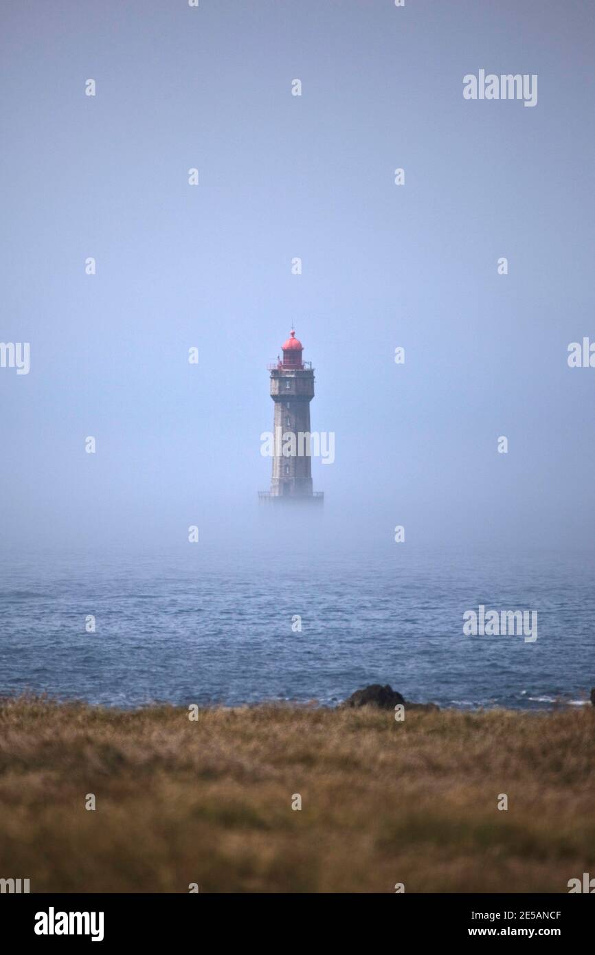 Der dramatische Leuchtturm La Jument, im Sommernebel geschrumpft, vor der Küste der Ile d'Ouessant in der Bretagne. Der ikonische 47 Meter hohe Leuchtturm war bui Stockfoto
