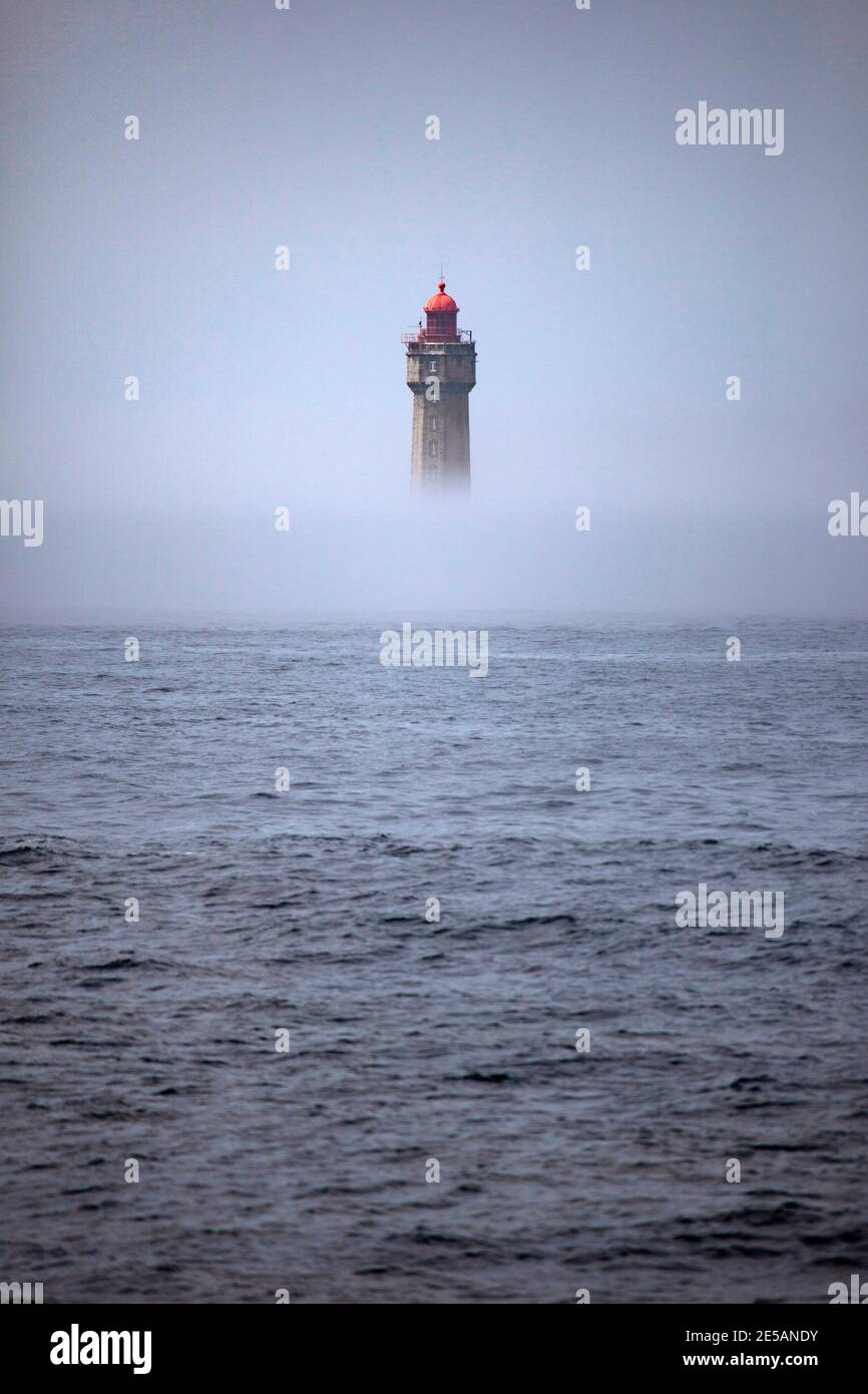 Der dramatische Leuchtturm La Jument, im Sommernebel geschrumpft, vor der Küste der Ile d'Ouessant in der Bretagne. Der ikonische 47 Meter hohe Leuchtturm war bui Stockfoto