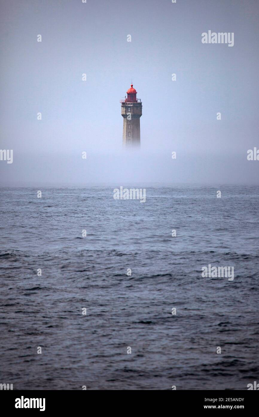 Der dramatische Leuchtturm La Jument, im Sommernebel geschrumpft, vor der Küste der Ile d'Ouessant in der Bretagne. Der ikonische 47 Meter hohe Leuchtturm war bui Stockfoto