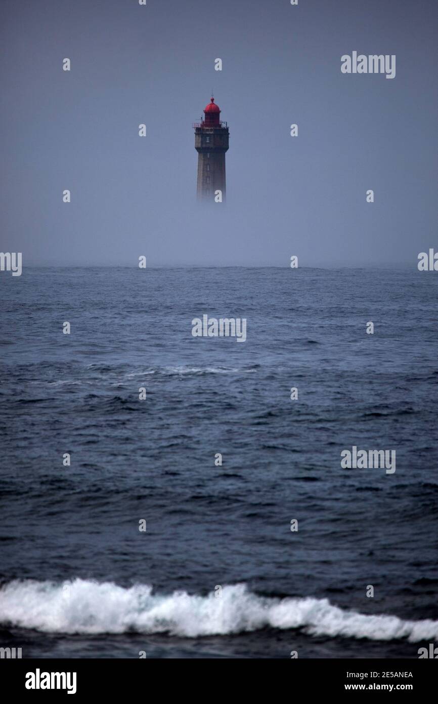 Der dramatische Leuchtturm La Jument, im Sommernebel geschrumpft, vor der Küste der Ile d'Ouessant in der Bretagne. Der ikonische 47 Meter hohe Leuchtturm war bui Stockfoto