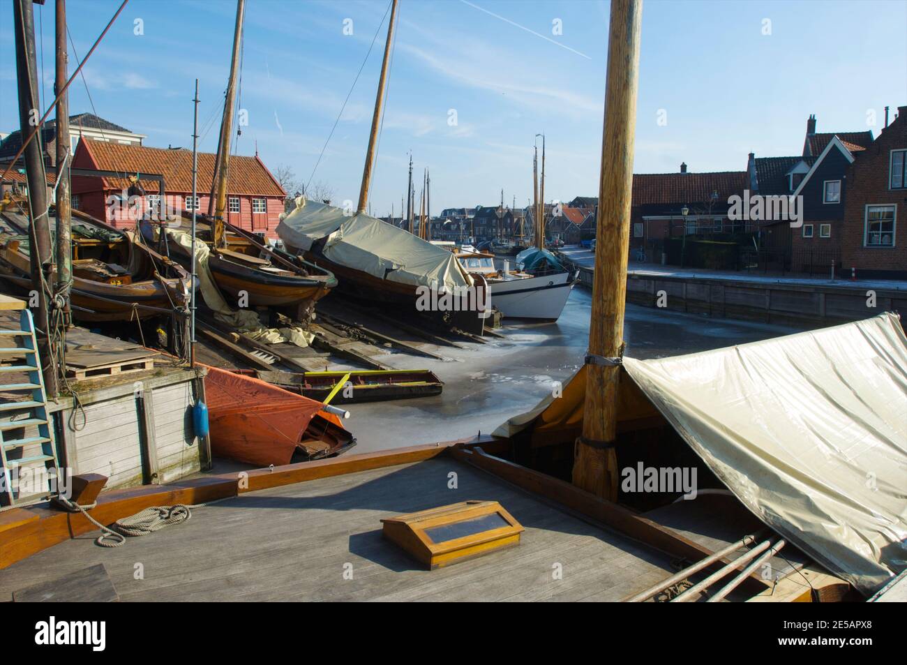 Das Freilichtmuseum mit dem Hafen des Dorfes Spakenburg mit Eis bedeckt mit Holzschiffen und die Werft im Winter, die Niederlande Stockfoto