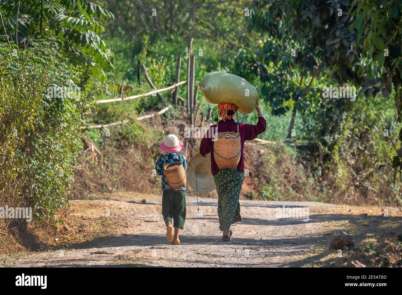 Frau und Mädchen tragen schwere Lasten in Burma, Myanmar Stockfoto