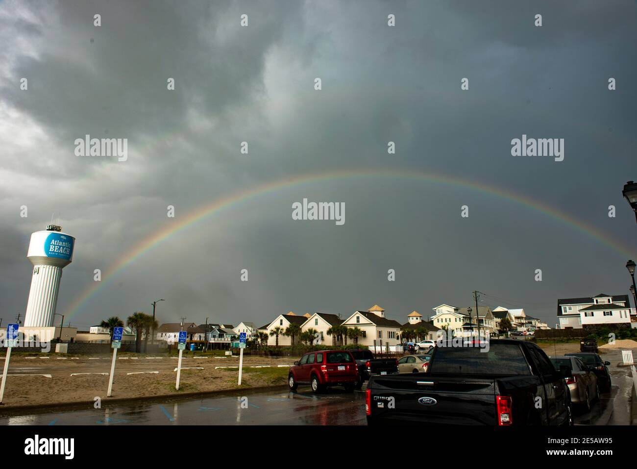 Ein Regenbogen leuchtet in der Sonne, nachdem ein Sturm durch Atlantic Beach, North Carolina, gegangen ist. Ein schwacher doppelter Regenbogen ist zu sehen. Stockfoto