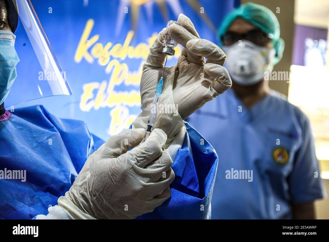 Medan, Indonesien. Januar 2021. Ein Gesundheitsfachkraft, der einen Schutzanzug trägt, hält eine Ampulle des Covid-19-Coronavirus-Impfstoffes in die Höhe, um es dem medizinischen Personal im RS Adam Malik Krankenhaus in Medan zu verabreichen. Kredit: SOPA Images Limited/Alamy Live Nachrichten Stockfoto