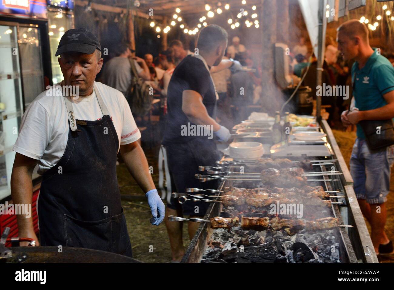 Velyki Sorochyntsy, Region Poltava, Ukraine - August 2016: Imbissstand auf dem Markt mit gegrilltem Fleisch auf dem Grill. Man fries Shish Kebab auf traditionelle Stockfoto