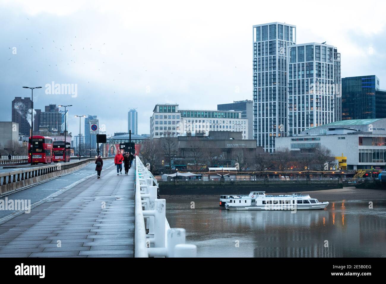 An einem kalten Wintertag laufen die Menschen entlang der Waterloo Brücke. Stockfoto
