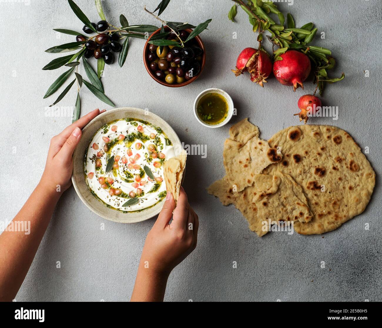 iranisches oder arabisches Gericht, Joghurt labneh Ziegen Milchdip mit Taftbrot und Granatapfel Stockfoto