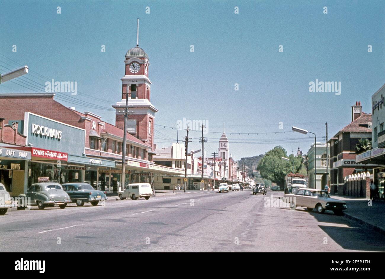 Am späten Morgen nach Westen in Dean Street, Albury, New South Wales, Australien im Jahr 1961. Die Dean Street befindet sich im zentralen Geschäftsviertel von Albury. Albury ist eine große regionale Stadt und liegt am Hume Highway und der Haupteisenbahn zwischen Sydney und Melbourne. Zu den Wahrzeichen auf der Straße gehören das CML- und das T&G-Gebäude. Stockfoto