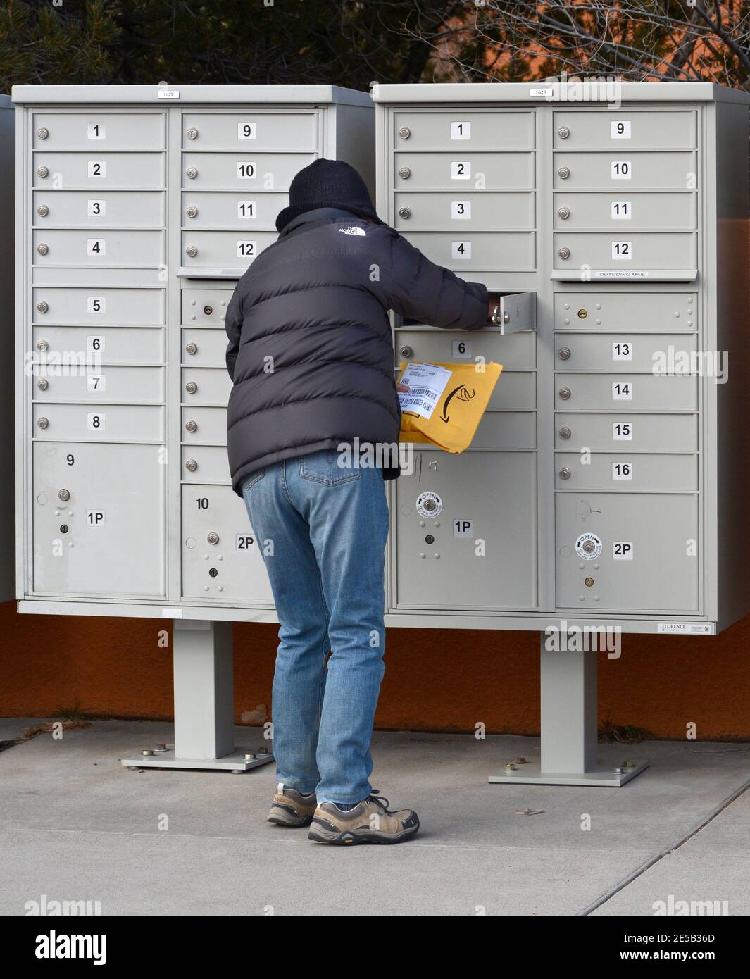 Eine Frau nimmt ihre Post an einer Wohnungs-Cluster-Mailbox in Santa Fe, New Mexico. Stockfoto