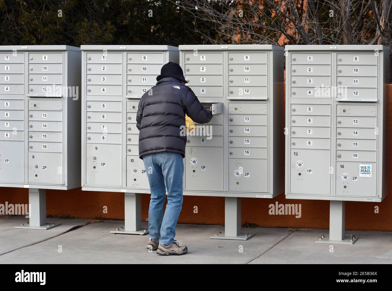 Eine Frau nimmt ihre Post an einer Wohnungs-Cluster-Mailbox in Santa Fe, New Mexico. Stockfoto