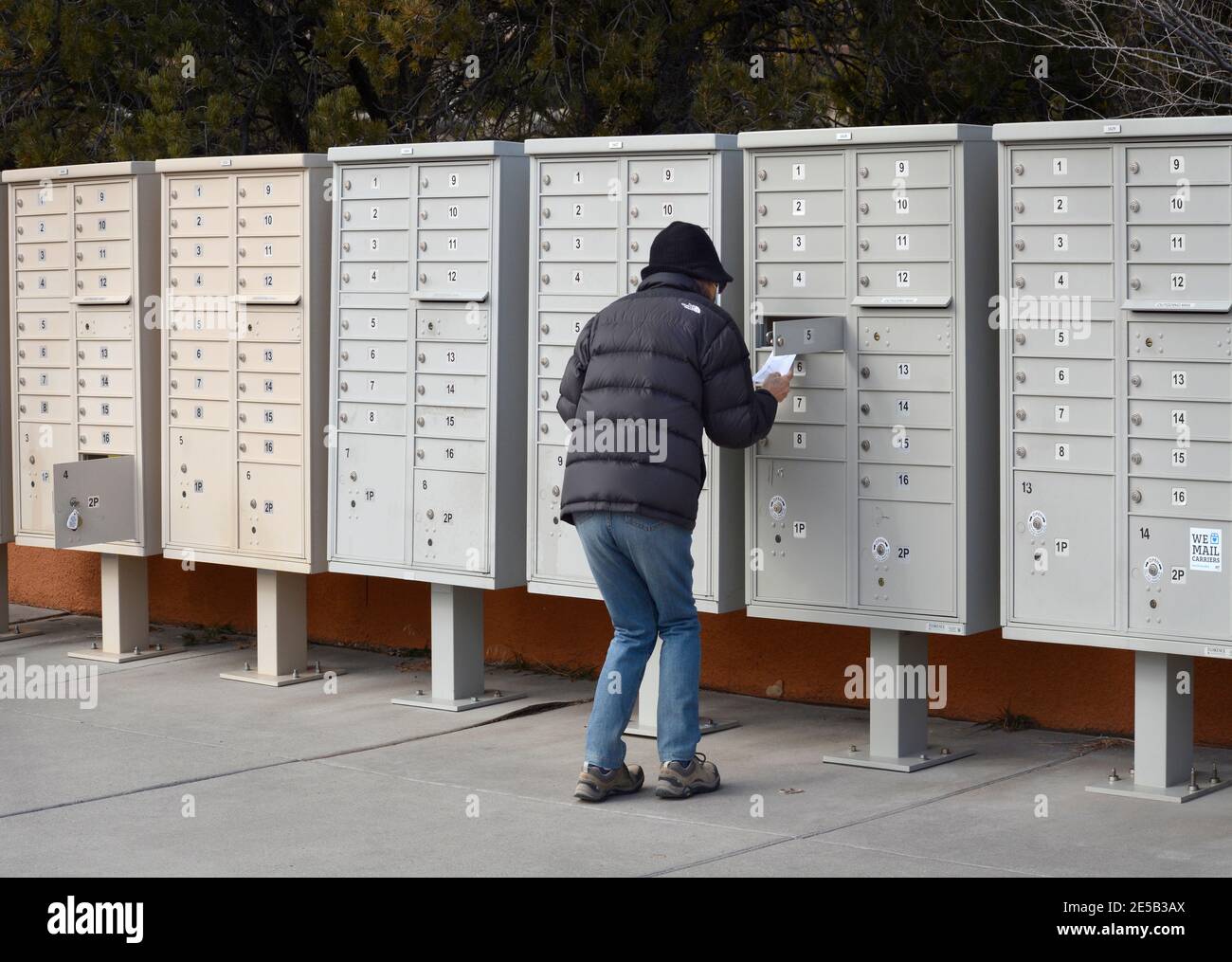 Eine Frau nimmt ihre Post an einer Wohnungs-Cluster-Mailbox in Santa Fe, New Mexico. Stockfoto