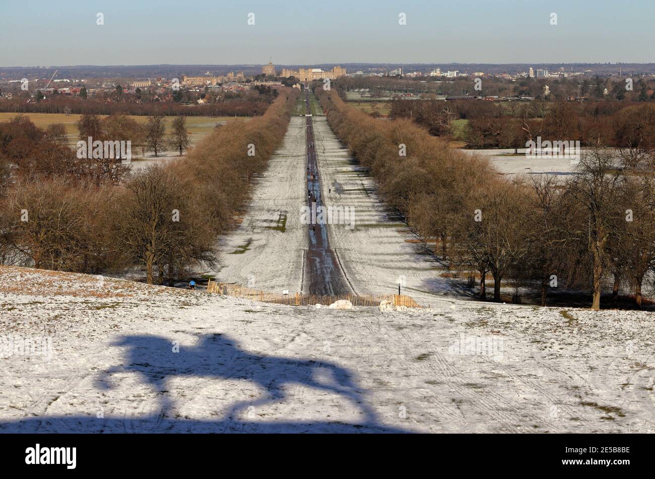 Windsor Castle von der langen Wanderung mit Licht bedeckt Von Schnee auf dem Boden und Schatten der Coppewr Horse Monument Stockfoto