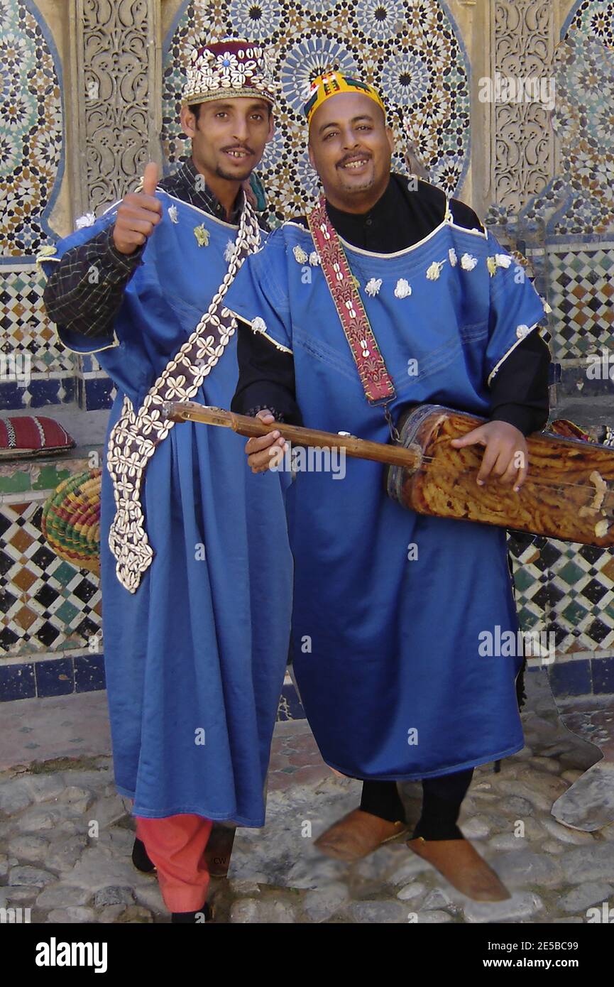 Straßenmusiker in Tanger, Marokko 2005 - der Mann auf der rechten Seite spielt eine gimbri (auch bekannt als sintir, guembri , gimbri, hejhouj oder hajhuj), eine Art Laute mit drei Saiten (gestimmt mit einer Stimmschlinge), die gezupft wird. Stockfoto
